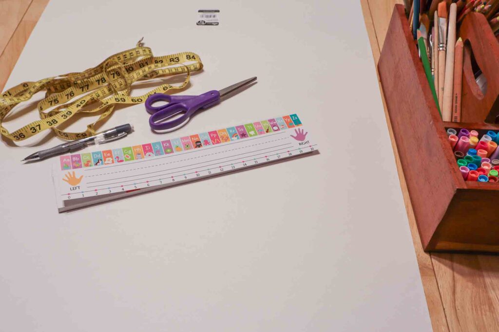 Picture of poster board, scissors, measuring tape, pencil, name plate, colored pencils, and markers.