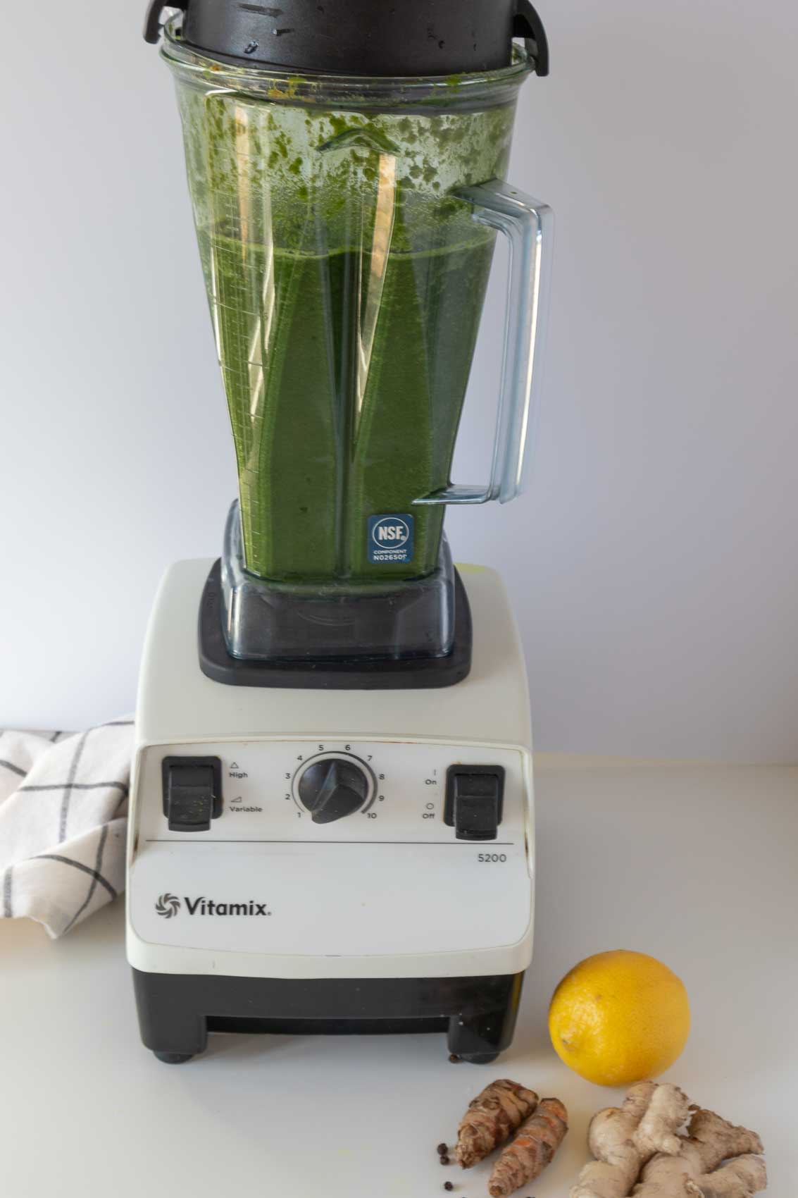 Process shot of blended greens and adding remaining coconut water.