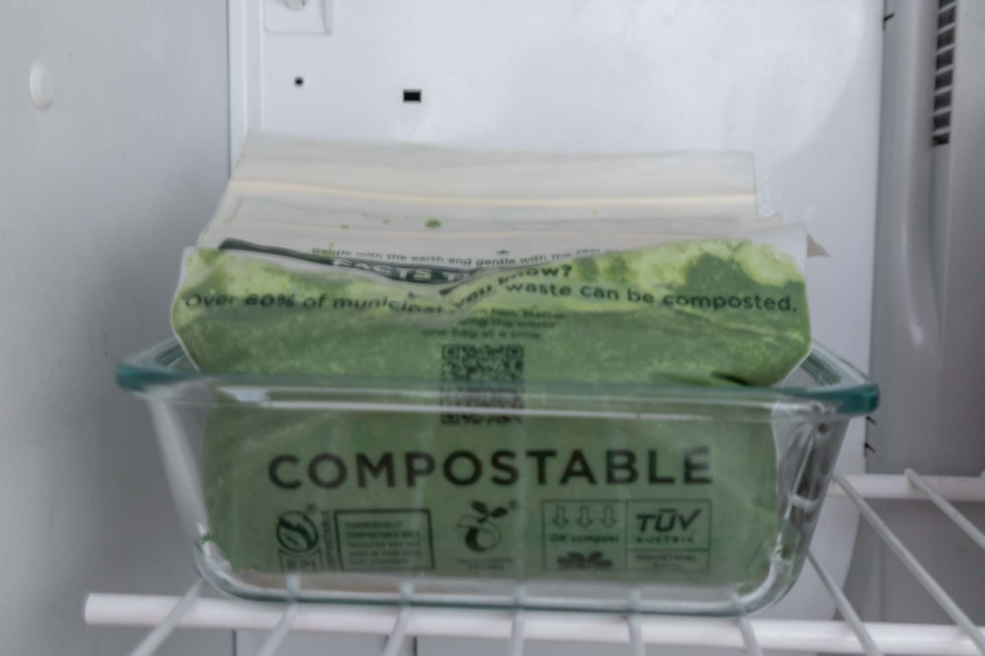 Process shot of green juice placed in bags in the freezer to freeze.